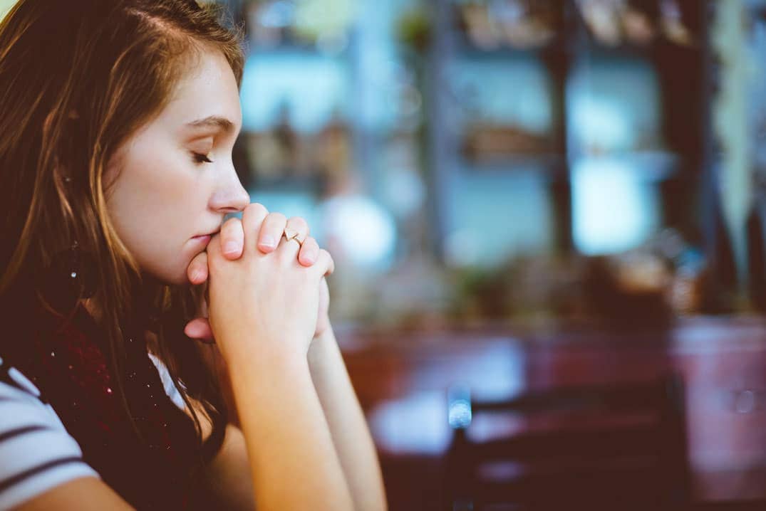 jeune femme en prière, mains jointes