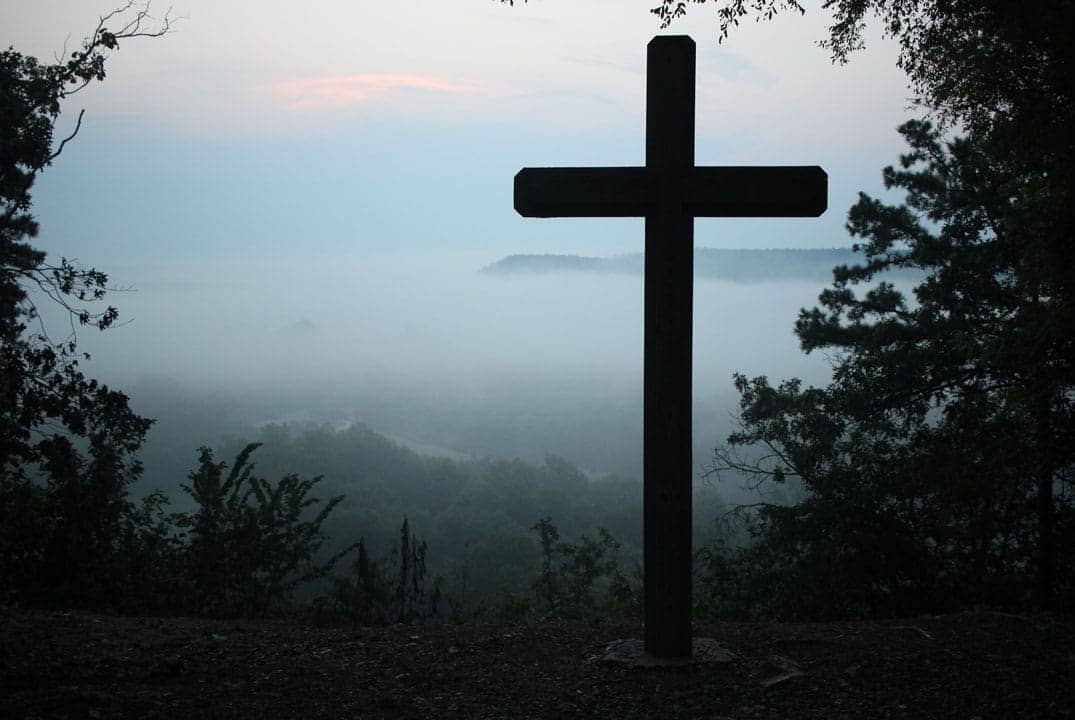 croix devant un paysage brumeux