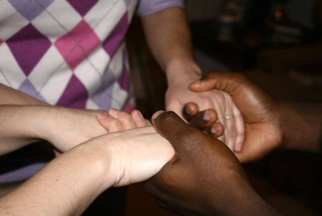 femmes se tenant les mains dans la prière